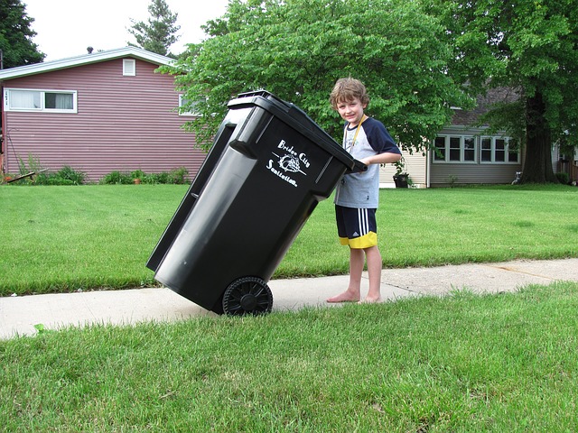 kid pushing garbage bin